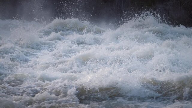 Turbulent whitewater surges violently through Sauble Falls on the Bruce Peninsula during spring. Thick foam rises into a heavy mist as cold droplets spray into the chilly air.