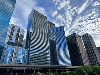 Fototapeta premium Modern Chicago Skyscrapers Glass and Steel Architecture Under Blue Sky with Clouds