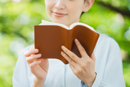 屋外で読書をする若い女性　ライフスタイルイメージ