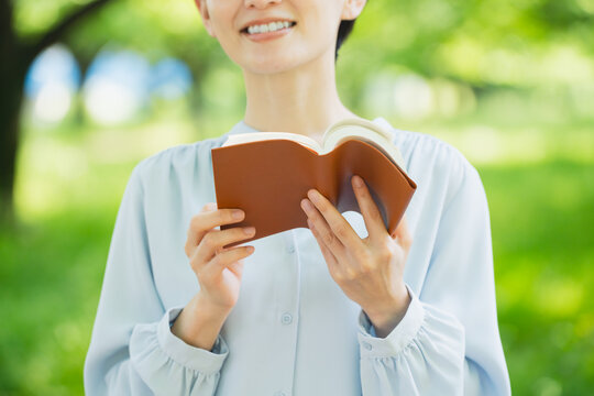 屋外で読書をする若い女性　ライフスタイルイメージ