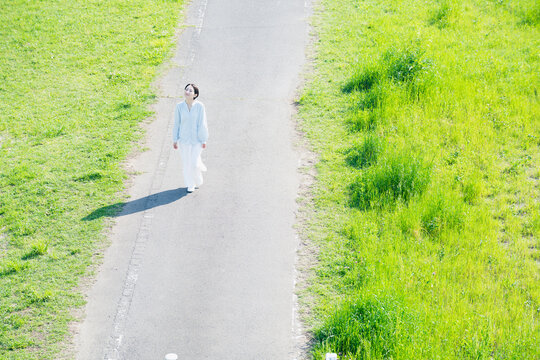 散歩道を歩く若い女性　ライフスタイルイメージ
