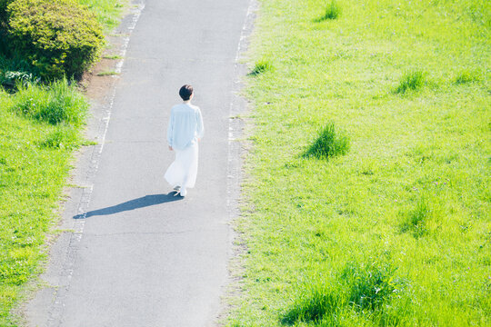 散歩道を歩く若い女性　ライフスタイルイメージ