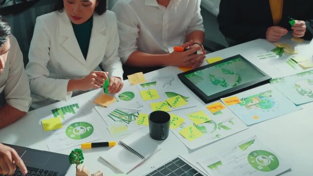 Close up of business people hands write notes about sustainable energy and environmental idea. Group of diverse people taking a note and brainstorming about green tech. Focus on hand. Alimentation.