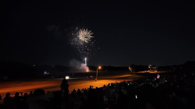 Red and green fireworks exploding over a crowd at night