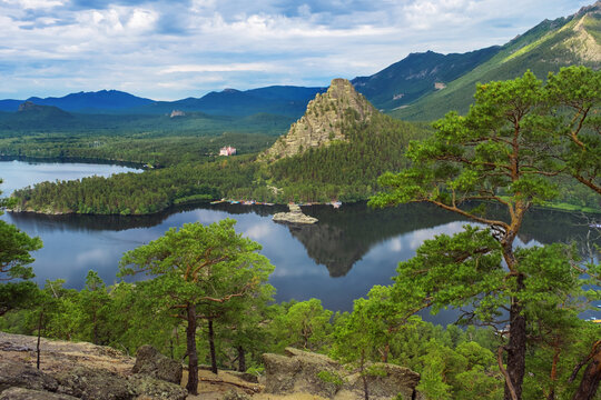 Panoramic view of Burabay Borovoe Lake and beautiful mountain Okzhetpes and rocky island Zhumbaktas, cloud blue sky. Burabay National Nature Park in Republic of Kazakhstan. Summer scenery landscape.