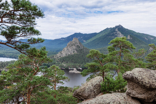 Panoramic view of Burabay Borovoe Lake and beautiful mountain Okzhetpes and rocky island Zhumbaktas, cloud blue sky. Burabay National Nature Park in Republic of Kazakhstan. Summer scenery landscape.