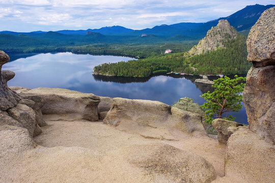 Panoramic view of Burabay Borovoe Lake and beautiful mountain Okzhetpes and rocky island Zhumbaktas, cloud blue sky. Burabay National Nature Park in Republic of Kazakhstan. Summer scenery landscape.