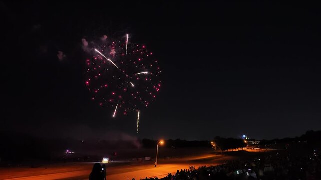 Colorful fireworks exploding over a crowd at night