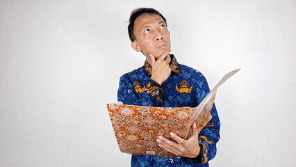 Young male civil servant having a thought in blue batik uniform