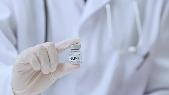 Confident doctor wearing white glove holds medication vial, offering hopeful clinical support for healthy weight loss journey