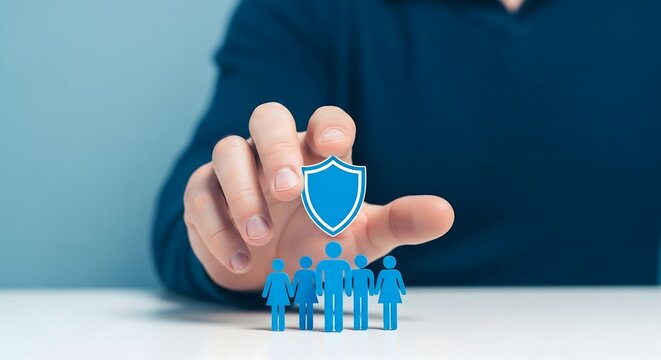 Man protecting blue paper people figures with a shield