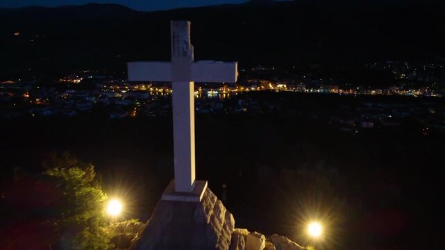 Drone flying away from white cross on glavica hill overlooking stari grad