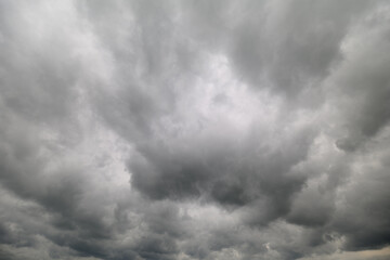 Obraz premium Dramatic gray clouds loom over the landscape, hinting at a brewing storm above the horizon, casting shadows on the earth below