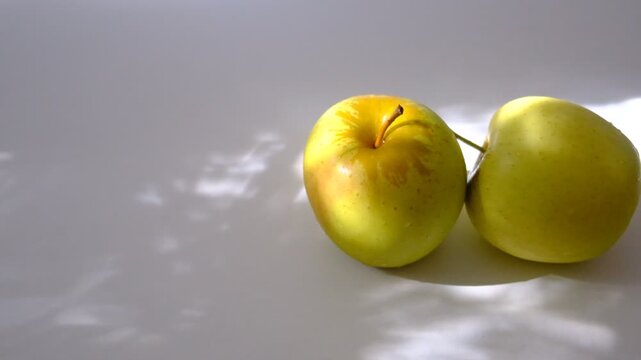 Fresh yellow apples fruits on the table basking in the soft light of an autumn afternoon, Autumn harvesting, Sunlight and shadow, healthy eating, atmospheric Mood