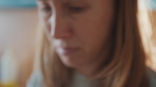 Woman drinks morning coffee on the kitchen from the white cup and dislikes it