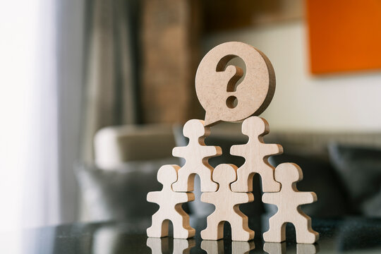 Human resources hierarchy and business problem solving concept. Wooden figures stack with question mark. Ideal for HR management, team confusion, corporate structure, and FAQ background.