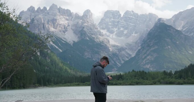 Man Flies Drone Camera At Lago di Landro Surrounded By The Dolomites Mountain Landscape In Northern Italy. Wide Shot