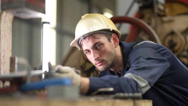 Industrial technician inspecting production equipment inside manufacturing factory. Machine maintenance, quality inspection, engineering support and industrial operations.