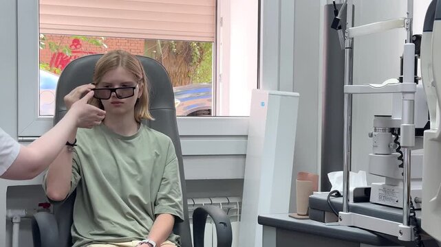 Young girl sitting in an eye clinic wearing special glasses during a vision test. optometry checkup, pediatric ophthalmology exam, medical consultation.