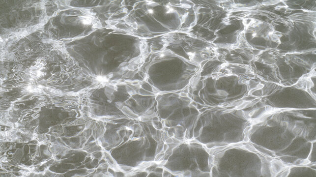 Abstract top view water surface with glowing bright sunlight reflections and ripples

