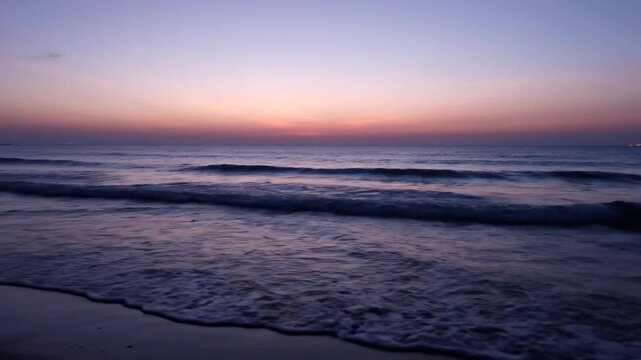 Calm ocean waves at dusk with soft pastel sky