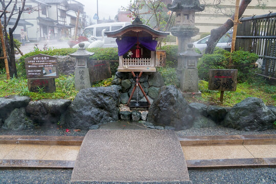 ISHIKAWA, JAPAN - NOVEMBER 15th 2015 -  A stone statue, lanterns and Japanese signs are displayed in a shrine garden in Kaga City.