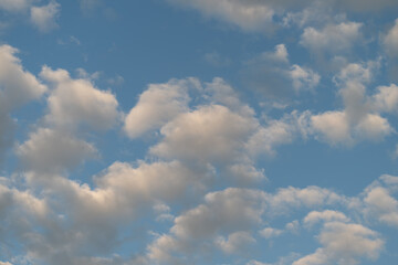Fototapeta premium Scattered cumulus clouds across a blue sky at golden hour