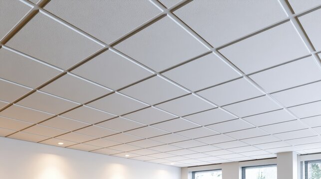 Minimalist ceiling design with uniform acoustic tiles and gentle daylight in a corporate workspace