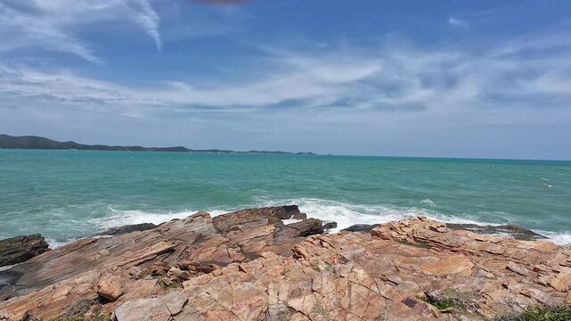 Strong summer winds whip the ocean waves against the rocks.