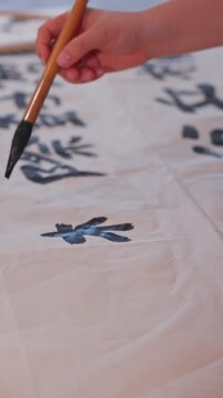 Close up view of hand holding brush writing neat Chinese calligraphy