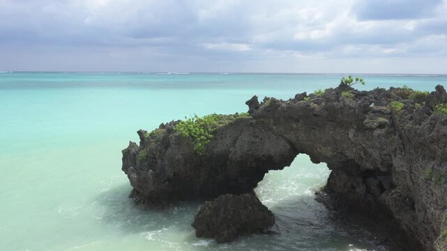 与論島・ゆいのおかの美しいエメラルドグリーンの海と琉球石灰岩のアーチ