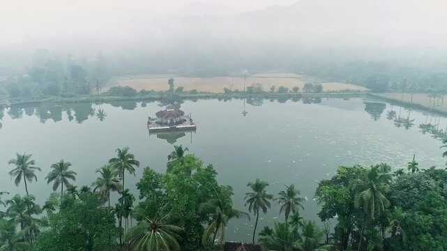 Aerial view of serene Kere Basadi temple floating within varanga Lake heritage landscape scenery