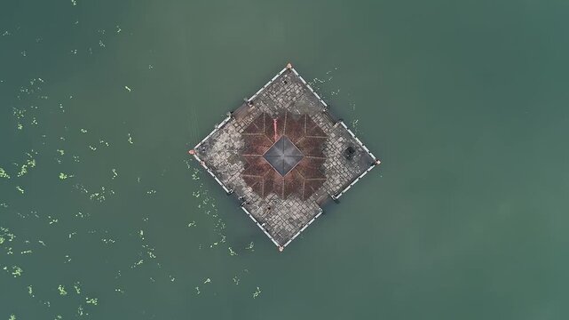 Aerial view of serene Kere Basadi temple floating within varanga Lake heritage landscape scenery