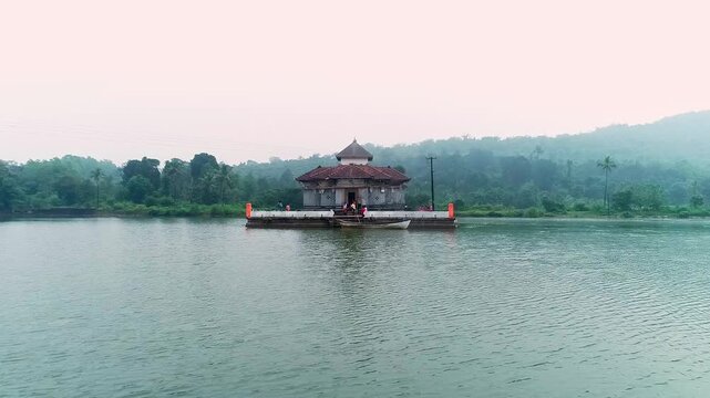 Aerial view of serene Kere Basadi temple floating within varanga Lake heritage landscape scenery