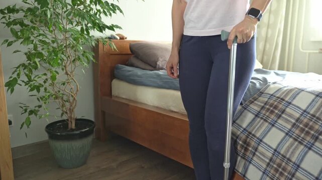 A patient recovering from a stroke walks with a cane.