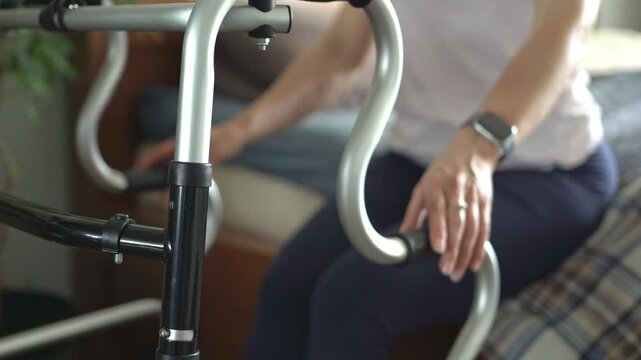 A stroke patient's hands grip a walker and rise from bed.