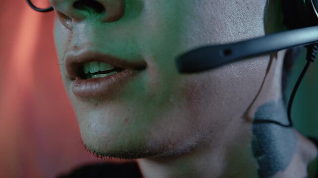 Close-up of a young tattooed person wearing glasses and talking into a headset microphone