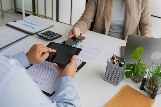 Asian business people using tablet and laptop working together