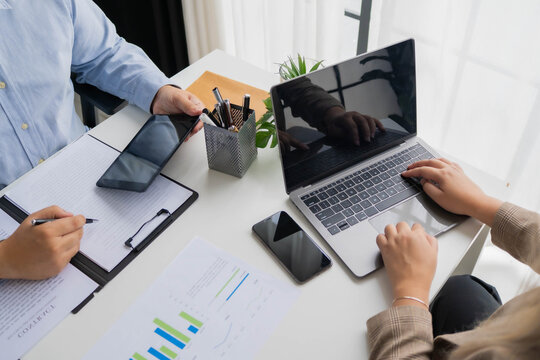 Asian business people using tablet and laptop working together