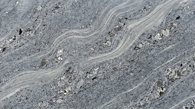 Silver gray granite stone texture. Natural polished marble surface with wavy patterns.