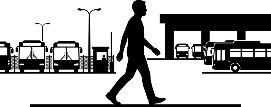 Silhouette of a man walking past parked transit buses at a depot