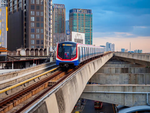 Bangkok, Thailand - July 8, 2026 :  The BTS Skytrain runs in and out of Ha Yaek Lat Phrao Station in the evening, offering views of office buildings and beautiful scenery. illustrative