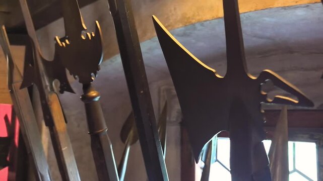 Intricate halberds stand quietly in a historic room, their sharp edges reflecting dim light. Each weapon tells a story of battles long past, echoing the spirit of medieval warriors.