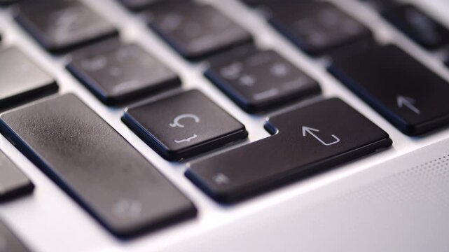Man pushing the enter button on a black keyboard.  Pressing Enter key on a laptop keyboard close up. Commercial concept representing final confirmation.