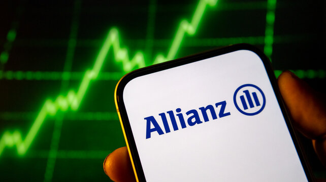 Smartphone displaying allianz insurance group logo held against glowing green stock market line graph background.