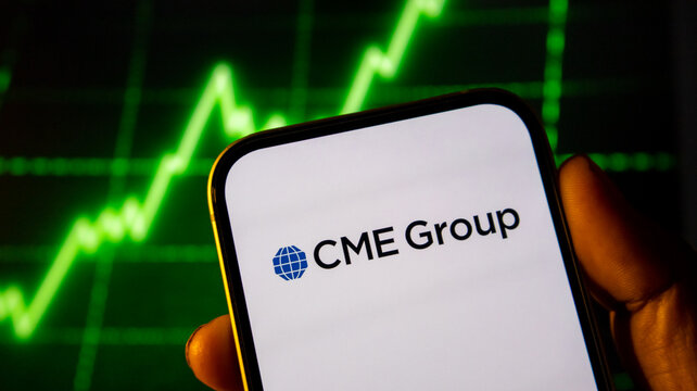 Financial mobile phone screen showing cme group logo with bright green rising stock market line in background.