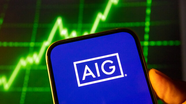 Aig insurance corporate logo visible on smartphone screen with digital stock market graph in background.