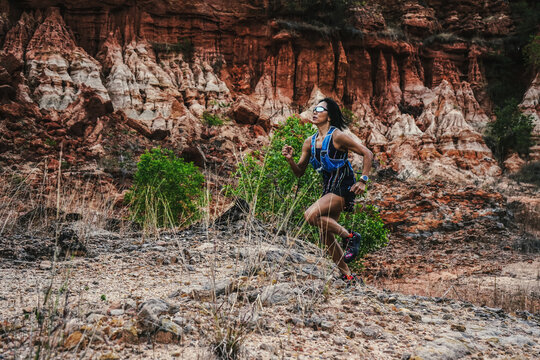 Female Trail Runner Training Through Rugged Rocky Landscape Duri