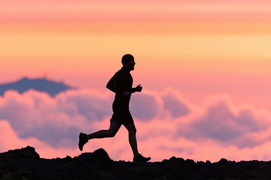 Running silhouette of a fit runner training for sport exercise in sunset fitness