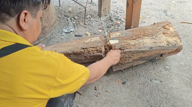 Person Arranging Dry Wooden Log on the Ground for a Campfire